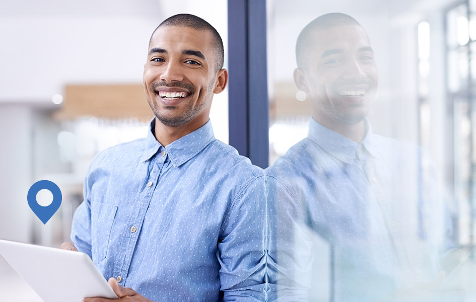 smiling man holding tablet with floating location icon