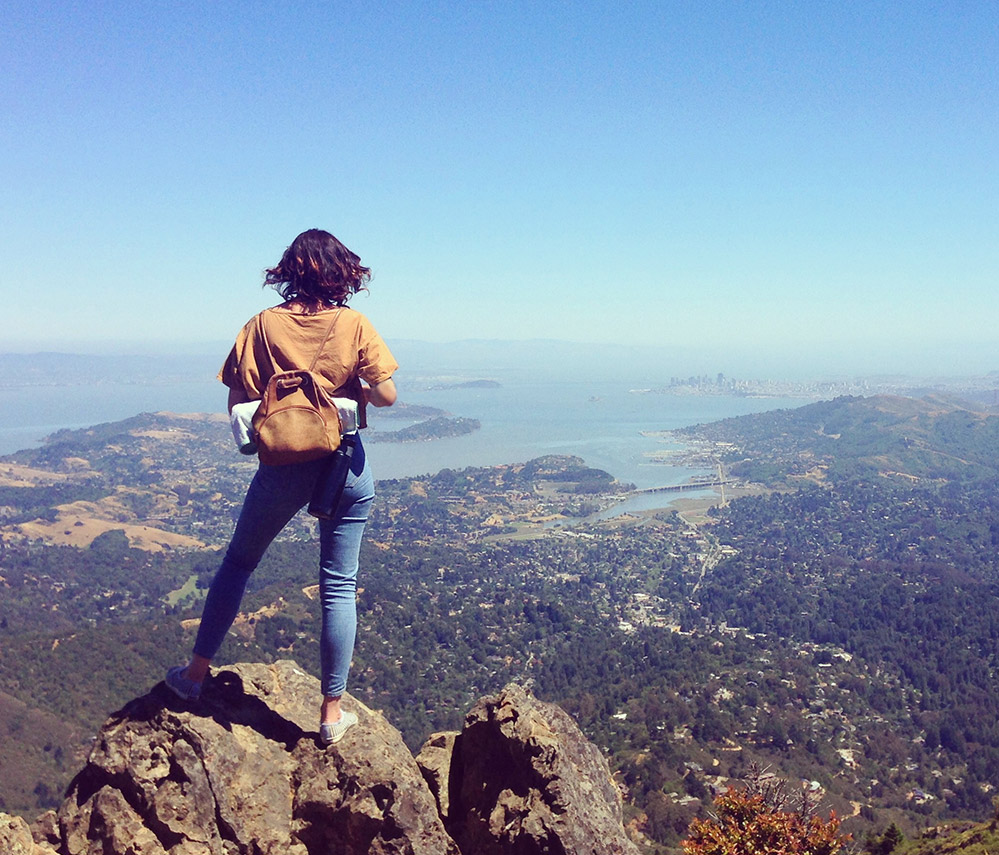 Woman staring out at landscape from mountain top